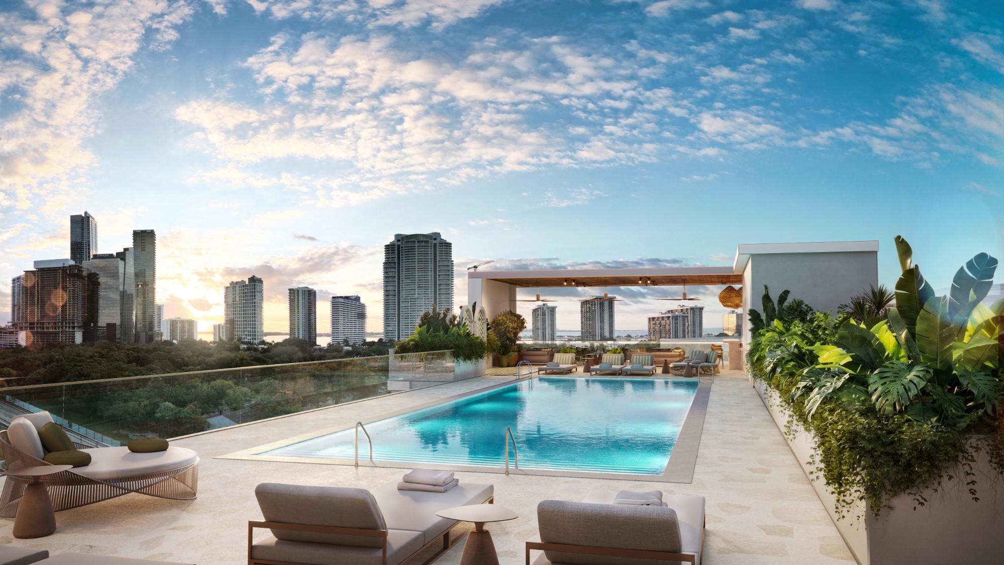 Piscina en la azotea de Parkside con camastros, bar cubierto y vista al skyline de Brickell y a la bahía